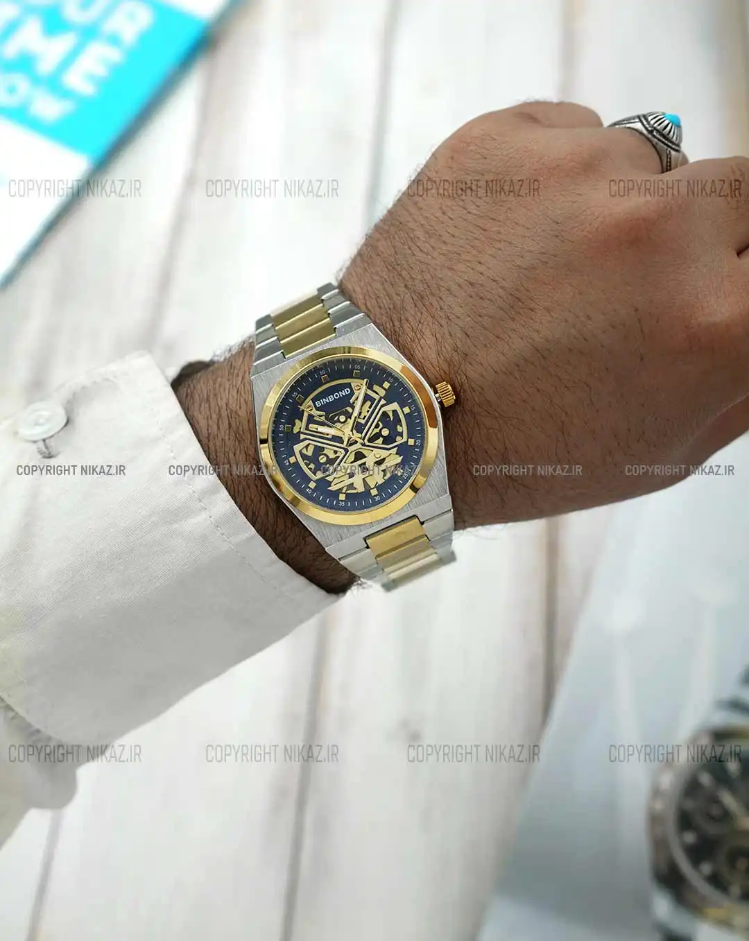 ساعت مچی مردانه بین باند BINBOND مدل B879 کد 1698 SBLG صفحه سرمه ای بند استیل نقره ای طلایی رنگ ثابت و موتور آرامگرد اسکلتون